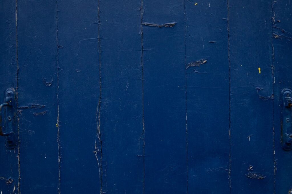 Detailed view of a weathered blue wooden surface in Paris, showcasing aged textures and patterns.