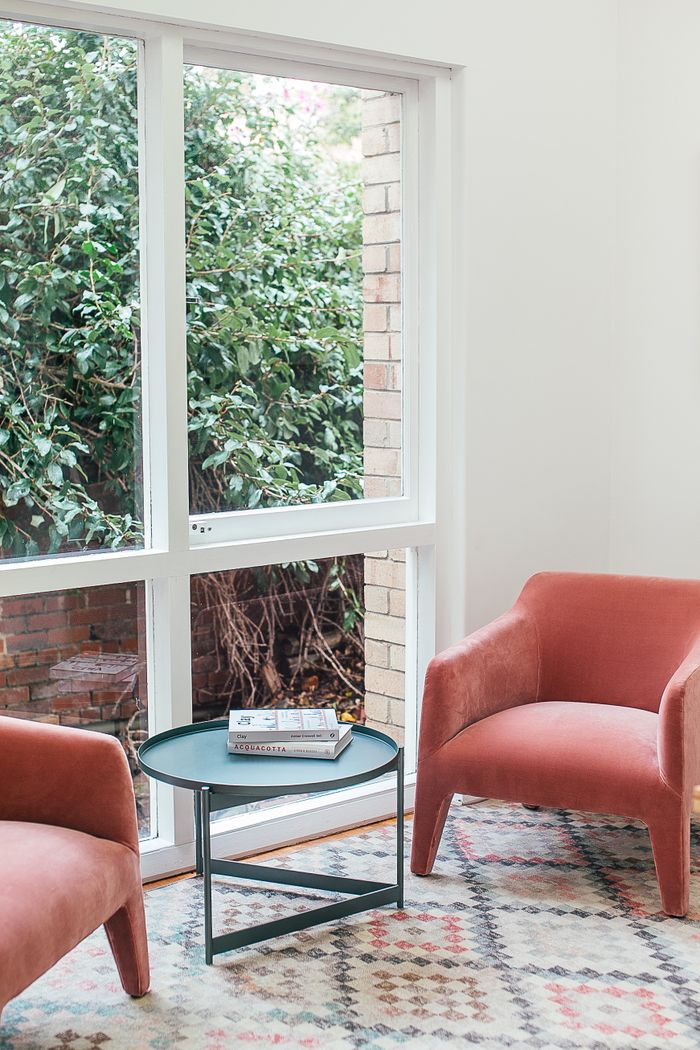Offerings Comfortable armchairs with small round table placed near window in cozy living room of spacious villa